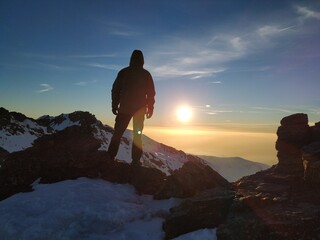 Hombre en montaña nevada viento la puesta de sol