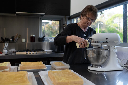 Senior lady making cakes for fundraising event