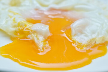 fried egg with creamy yolk flowing on plate
