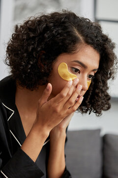 Woman applying under eye gel patch