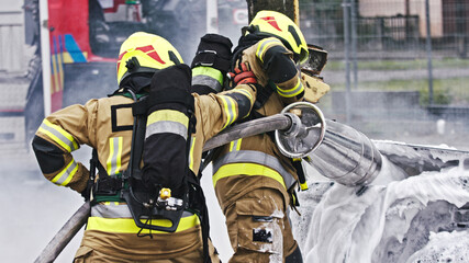  Fire drill. Firefighters extinguish fire from the nurning car using the foam. High quality photo