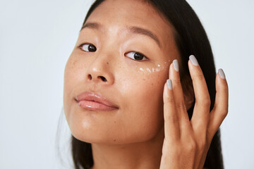 Woman applying under eye corrector