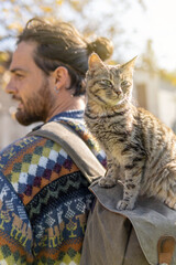 A man with a cat on top of his backpack