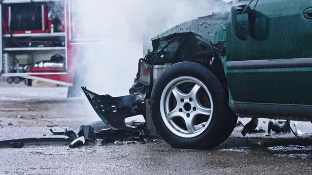 Smoke from wrecked car with fire engine in the background. Car accident. High quality 4k footage