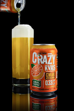 Kiev, Ukraine - August 17, 2020: Traditional drink white kvass taras in a metal orange can isolated on a black background with reflection