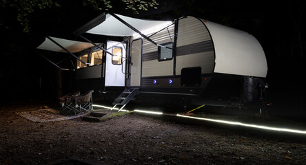 Ground lights illuminating the outside a travel trailer for added safety with the camper's awnings...