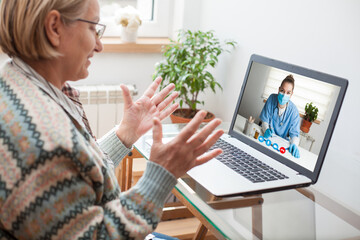 Elderly caucasian woman interacting with young female doctor via video call,medical worker seeing...