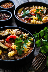 Pork ragout with fusilli and champignon on wooden table
