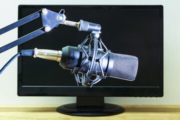 Studio microphone on the background of a computer monitor.