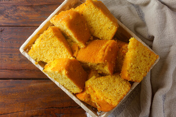 corn cake sliced in basket on rustic wooden table for breakfast. Typical Brazilian food