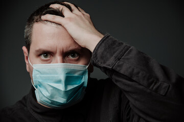 a man wearing a medical mask with a headache