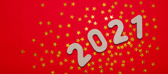 Merry Christmas and New year 2021 - Golden numbers on a red - orange background with sparkling stars. Copy space and flat lay. Space for text.