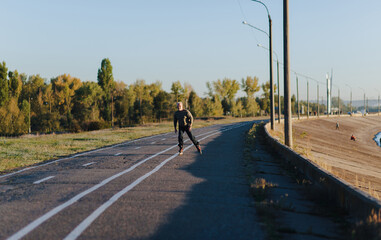 Obraz premium The old gray-haired man goes on rollers in the autumn park. Happy pensioner. Active old people.