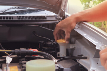 A man checking car engine at home, worker.