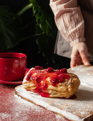 Puff pastry dessert red jam hand viburnum cherry cup coffee black background