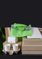 delivery service box green vest cup coffee workplace table a lot note tablet