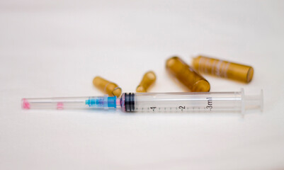 Empty medical ampoules infusion and used syringe after injection isolated on white background