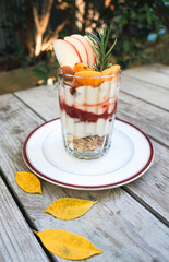 Strawberry smoothies, yoghurt and fresh fruit granola in a glass on wooden table table.