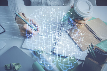 Multi exposure of writing hand on background with brain hologram. Concept of self learning.