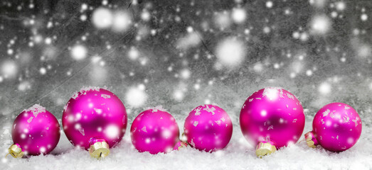 pink christmas ball with snow on grey background 