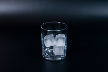 A glass with ice cubes in the center of the screen.