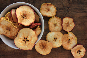 Dried fruits apples rings in a bowl, on wooden background. Top view. Rustic style