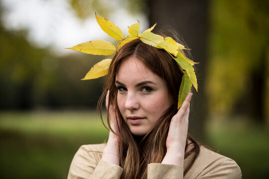 Close-up Portrait Of Beautiful Young Woman Holding Leaf Crown