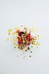 Fototapeta na wymiar Open festive box with tinsel and confetti. Celebrating Christmas or New Years or winning a prize or a promotion or other holiday concept.