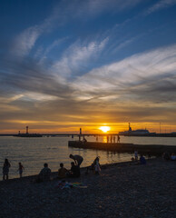 Obraz premium People at the beach at sunset