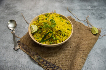 Coriander and peanut poha in a bowl on a background