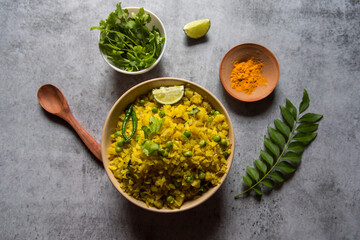 Top view of breakfast item poha or flattened rice along with condiments. Selective focus.