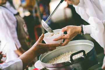 The hands of the poor get free food from the volunteers : the concept of ​​sharing food