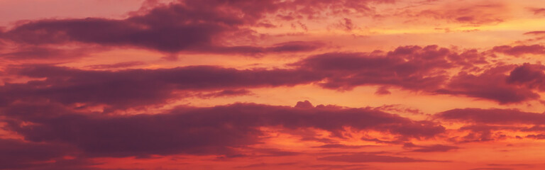 Dramatic ominous evil sky. Beautiful dramatic colorful purple red clouds on sky at sunset or sunrise. Evening or morning sky. Natural eco surface textured background. Web banner header.