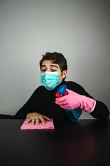 hombre joven con mascarilla guantes y desinfectante limpiando - obrazy, fototapety, plakaty