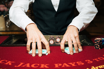 Croupier hands dealing cards on t blackjack poker table, gambling table with cards and chips
