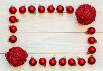 Naklejka na ściany i meble A frame of red baubles on a white wooden background with copy space.