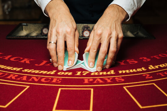 Croupier hands dealing cards on t blackjack poker table, gambling table with cards and chips