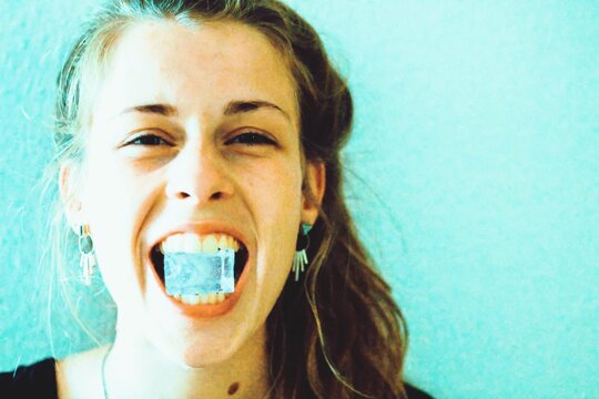 Portrait Of Young Woman Holding Ice Cube In Mouth