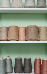 Pile of big colorful spools of yarn on shelving