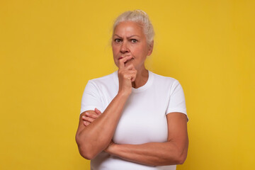 Upset senior woman lost in thoughts, miss old days, thinking or pondering.