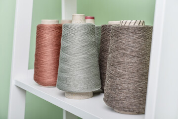 Pile of big colorful spools of yarn on shelving