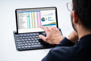 Analyst Using Spreadsheet Report On Tablet