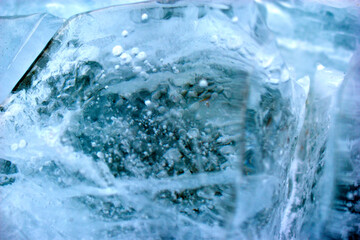 Fototapeta na wymiar Blue blocks of ice close up with bubbles and cracks