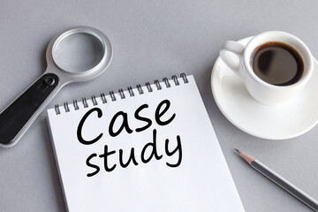 case study, text on white paper notepad on gray background near coffee cup and magnifying glass