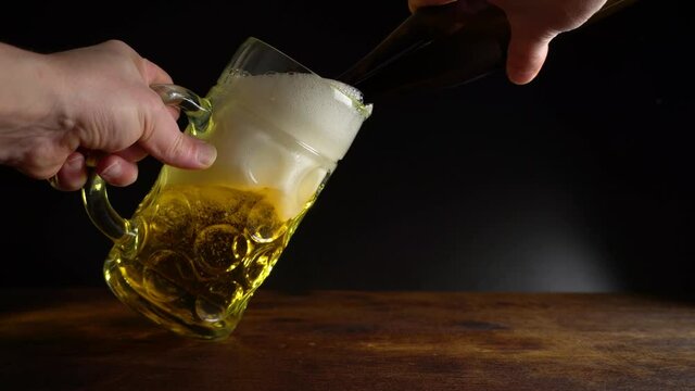 Pouring Beer in a big Oktoberfest Glass on black Background