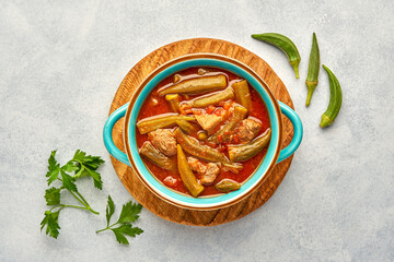 Homemade okra and meat stew in a pot. Top view, copy space