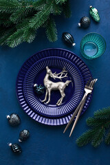 Christmas festive dinner table setting in dark blue tones