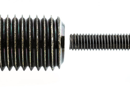 A background made from a macro shot of a grease coated black screw thread, isolated on a white background, comparison of large thread with small thread.