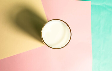 A glass of milk on a colored background of pastel colors.