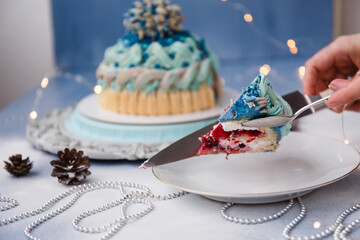 
Delicious and beautiful Christmas cake in the form of a knitted hat, sprinkled with powdered sugar. Vanilla biscuit with cranberry filling. New year cake